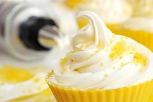 Creamy swirl of vanilla frosting on cupcake in silicone baking c