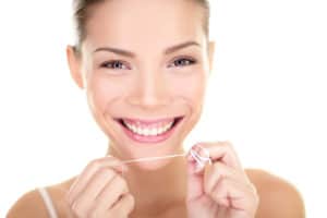 Dental flush - woman flossing teeth smiling happy with perfect t